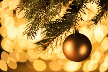 çam ağacı ile bokeh ışıklar arka plan asılı altın Noel top görünümünü kapat