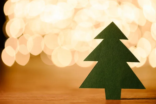 木製卓上コピー スペース ライト背景のボケ味 緑紙のクリスマス ツリーのビューをクローズ アップ — ストック写真