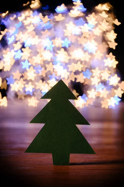 Nahaufnahme Von Grünem Papier Weihnachtsbaum Auf Hölzerner Tischplatte Und Bokeh — Stockfoto