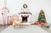 zařízený pokoj s houpací křeslo, vánoční stromek a dárky pro zimní dovolenou oslavu
