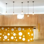 Lamps and yellow reception desk in modern kindergarten interior
