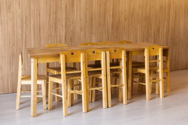 ahşap masa ve anaokulu odasında küçük sandalyeler 