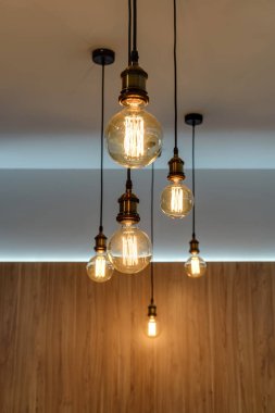 close-up view of illuminated light bulbs hanging in empty room clipart