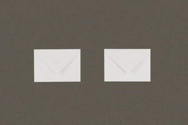 close-up view of two white envelopes arranged isolated on grey background