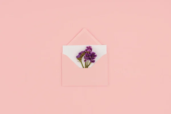 Верхний Вид Открытого Розового Конверта Белой Карточкой Небольшими Фиолетовыми Цветами — стоковое фото