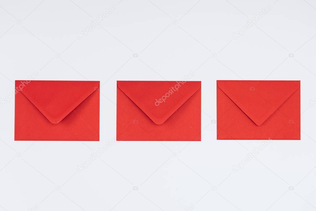 close-up view of three closed red envelopes isolated on white background