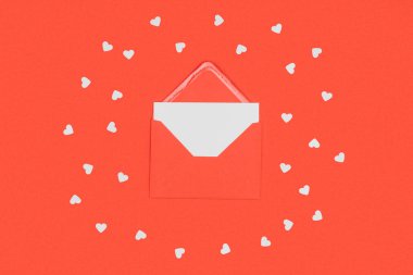close-up view of red envelope with white card and small hearts isolated on red  clipart