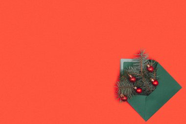 çam çırpı ve izole kırmızı parlak Noel baubles ile yeşil zarf 