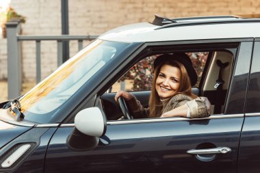 kareli ceket ve siyah şapka kentsel Street arabada oturan neşeli kadın