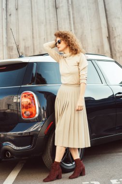  şık zencefil kadın modeli kentsel Street car yakınındaki poz güneş gözlüğü 