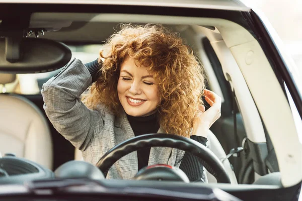 車の中に座って目を閉じて幸せな美しい巻き毛生姜女 — ストック写真