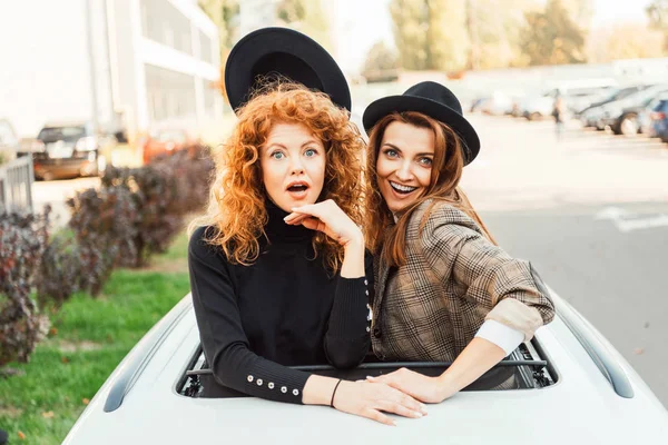 Cheerful Woman Taking Black Hat Her Shocked Female Friend While — Stock Photo, Image