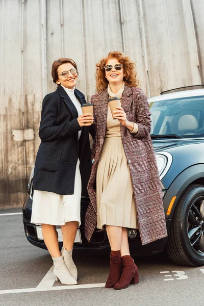 Laughing Female Friends Coats Drinking Coffee Car Urban Street — Stock Photo, Image