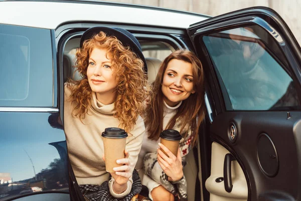 Szczęśliwy Szykowny Koleżanki Jednorazowe Kubki Kawą Patrząc Samochodu Ulicy — Darmowe zdjęcie stockowe