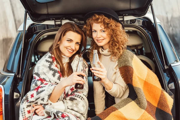 Selective Focus Happy Women Wrapped Blankets Holding Soda Bottles Sitting — Free Stock Photo