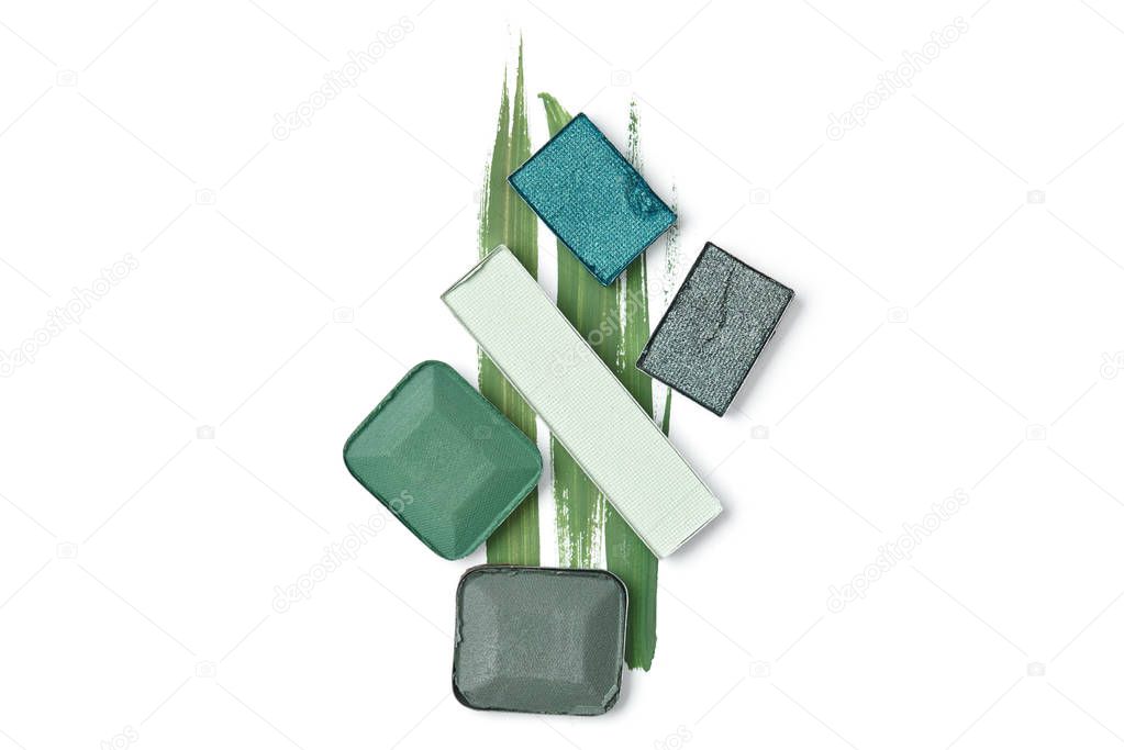 flat lay with arranged eyeshadows of green shades isolated on white 