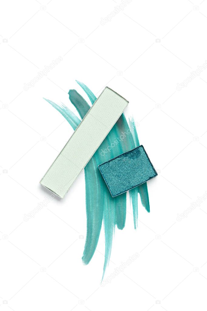flat lay with arranged eyeshadows of blue shades on white background