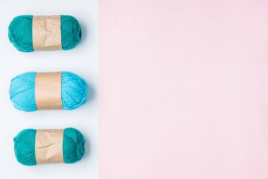 düz lay ile düzenlenmiş mavi iplik clews beyaz ve pembe arka plan üzerinde
