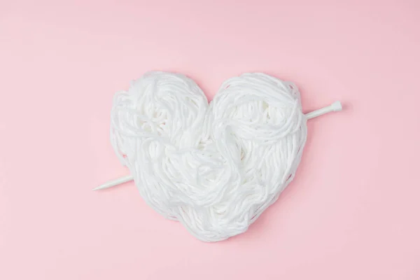 Top View Yarn Arranged Heart Symbol Knitting Needle Pink Backdrop — Stock Photo, Image