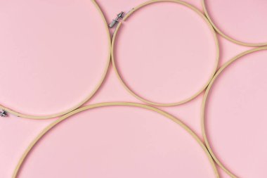 flat lay with wooden embroidery hoops arranged on pink background clipart
