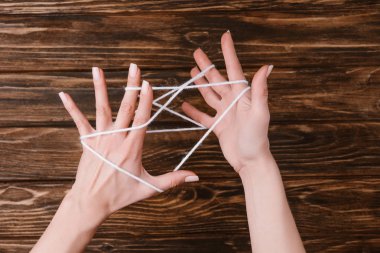 kısmi görünümünü beyaz iplik örme için ahşap masa üstü ellerinde tutan kadın