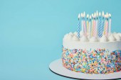 Lahodné narozeninový dort se svíčkami osvětlení na modrém pozadí
