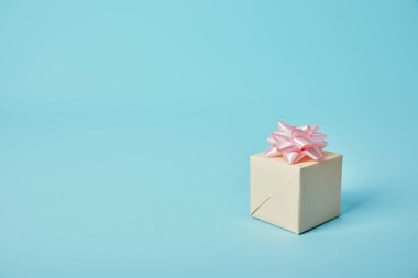 Mavi arka plan üzerinde pembe Fiyonklu hediye kutusu