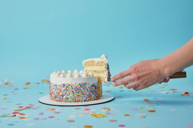 Partial view of woman taking piece of delicious cake on blue background clipart