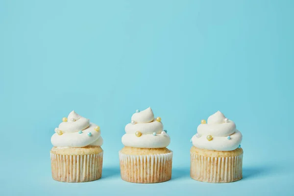 Leckere Cupcakes Mit Zuckerstreusel Auf Blauem Hintergrund — Stockfoto