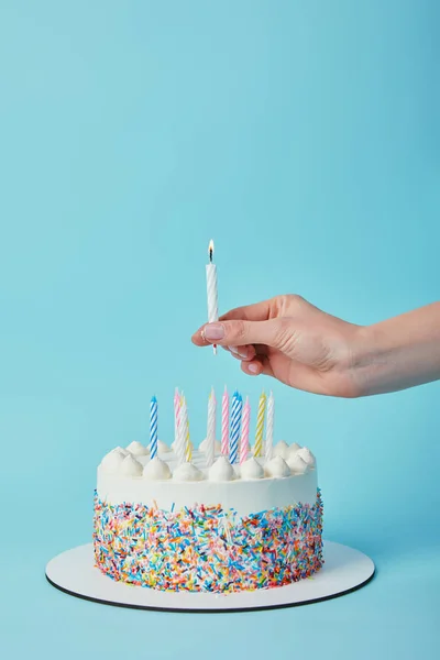 青の背景にお誕生日ケーキを照明キャンドルをかぶる女の部分的なビュー — ストック写真