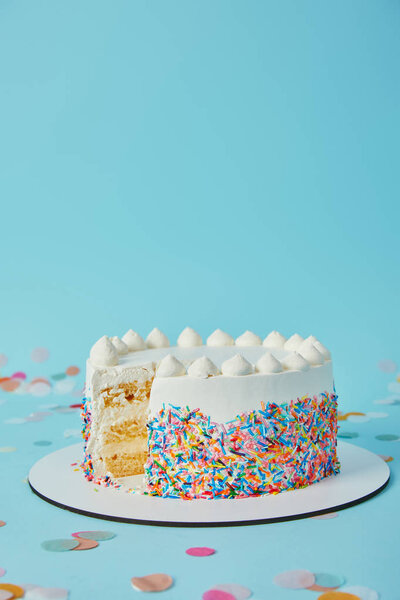 Delicious cake cut into pieces on blue background