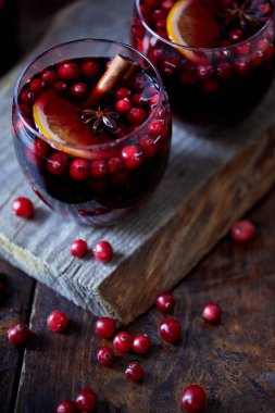 high angle view of homemade mulled wine with cranberries and cinnamon stick on board in kitchen clipart