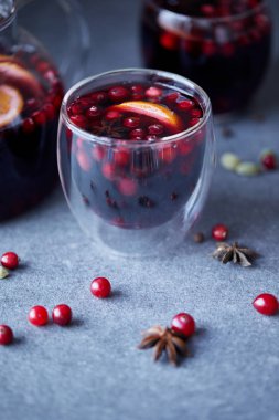homemade mulled wine with cranberries on grey tabletop in kitchen clipart