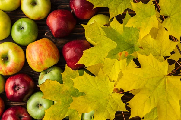 Pohled Shora Zralé Vícebarevné Jablek Žluté Maple Listy Dřevěný Stůl — Stock fotografie