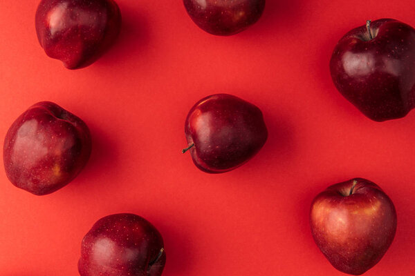 top view of delicious large apples on red background