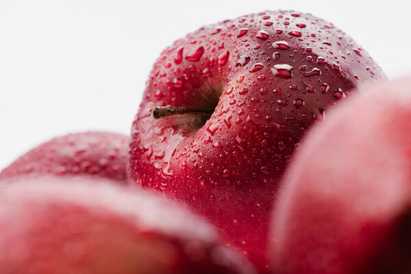 close up view of red delicious apples with water drops isolated on white