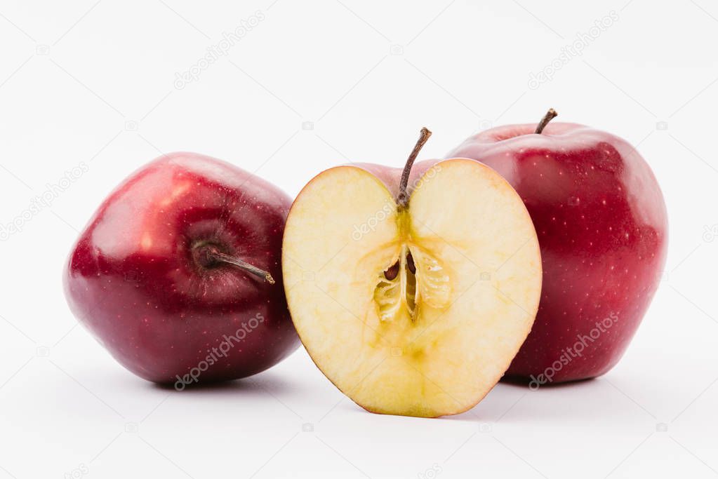 cut and whole red delicious apples on white background
