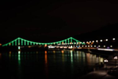illuminated bridge with blurred bokeh lights at night clipart