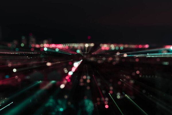 темный городской пейзаж с размытым ярким освещением ночью
