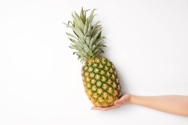 Kırpılan görünümünü tatlı ananas beyaz arka plan üzerinde elinde tutan kadın 