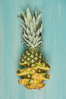 dilimlenmiş sarı ananas üstten görünüm turkuaz ahşap tablo
