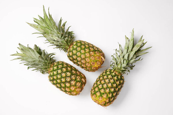 top view of tasty exotic pineapples on white background