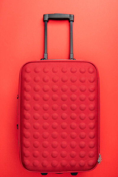 top view of travel bag on red background 