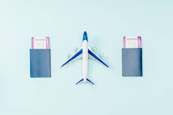 top view of passports, air tickets and toy plane on blue background 