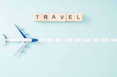 oyuncak uçak, noktalı çizgi ve tahta küpleri ile mavi arka plan seyahat yazı üstten görünüm