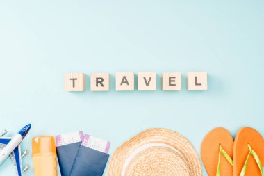 üstten görünüm ahşap küpleri ile yazı, hasır şapka seyahat, flip flop, pasaportlar ve mavi arka plan üzerinde uçak bileti