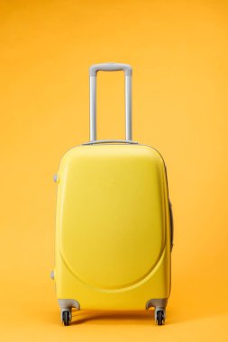 seyahat çantası tekerlekli ve sarı zemin üzerine idare