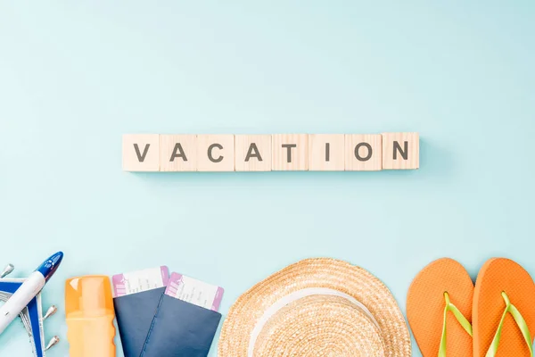木製キューブの上面旅行の文字 麦わら帽子 サンダル パスポートや航空券青の背景に — ストック写真