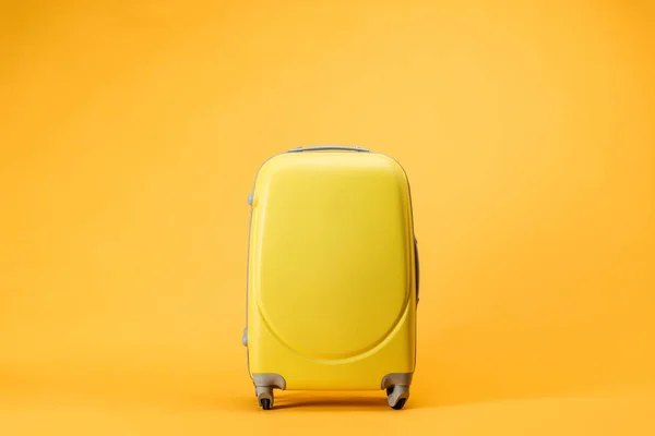 黄色の背景にバッグの車輪を旅行します — ストック写真
