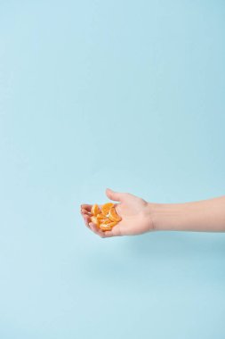 lezzetli dilim tutan kadın kırpılmış görünümünü mandalina el üzerinde izole mavi soyulmuş 